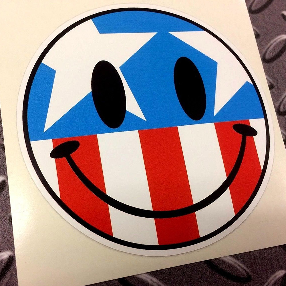 AMERICA USA SMILEY STICKER. A red, white and blue Stars and Stripes round smiley face. The eyes and mouth are black.
