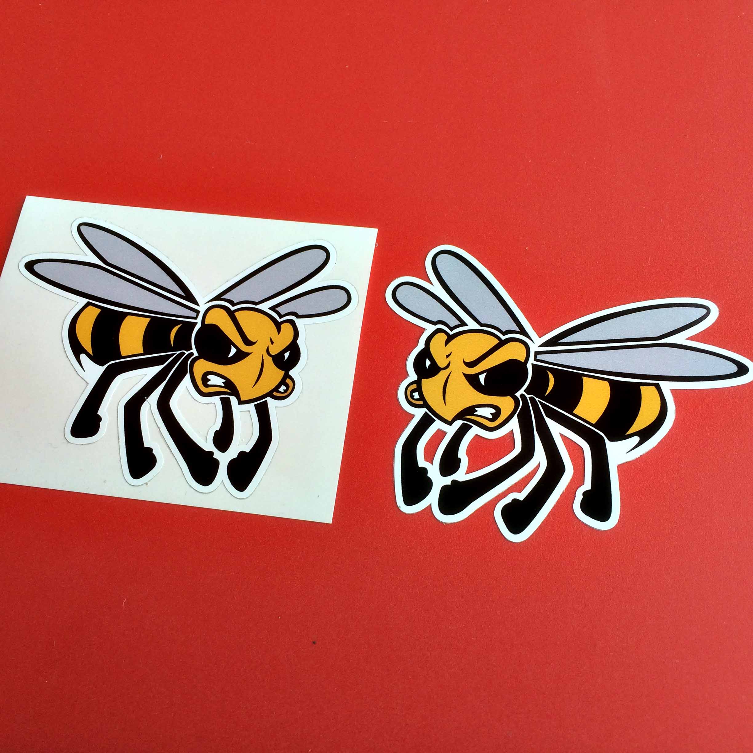 ANGRY WASP STICKERS WITH LEGS. A black and yellow wasp in flight. Displaying wings and legs. It has an angry face.
