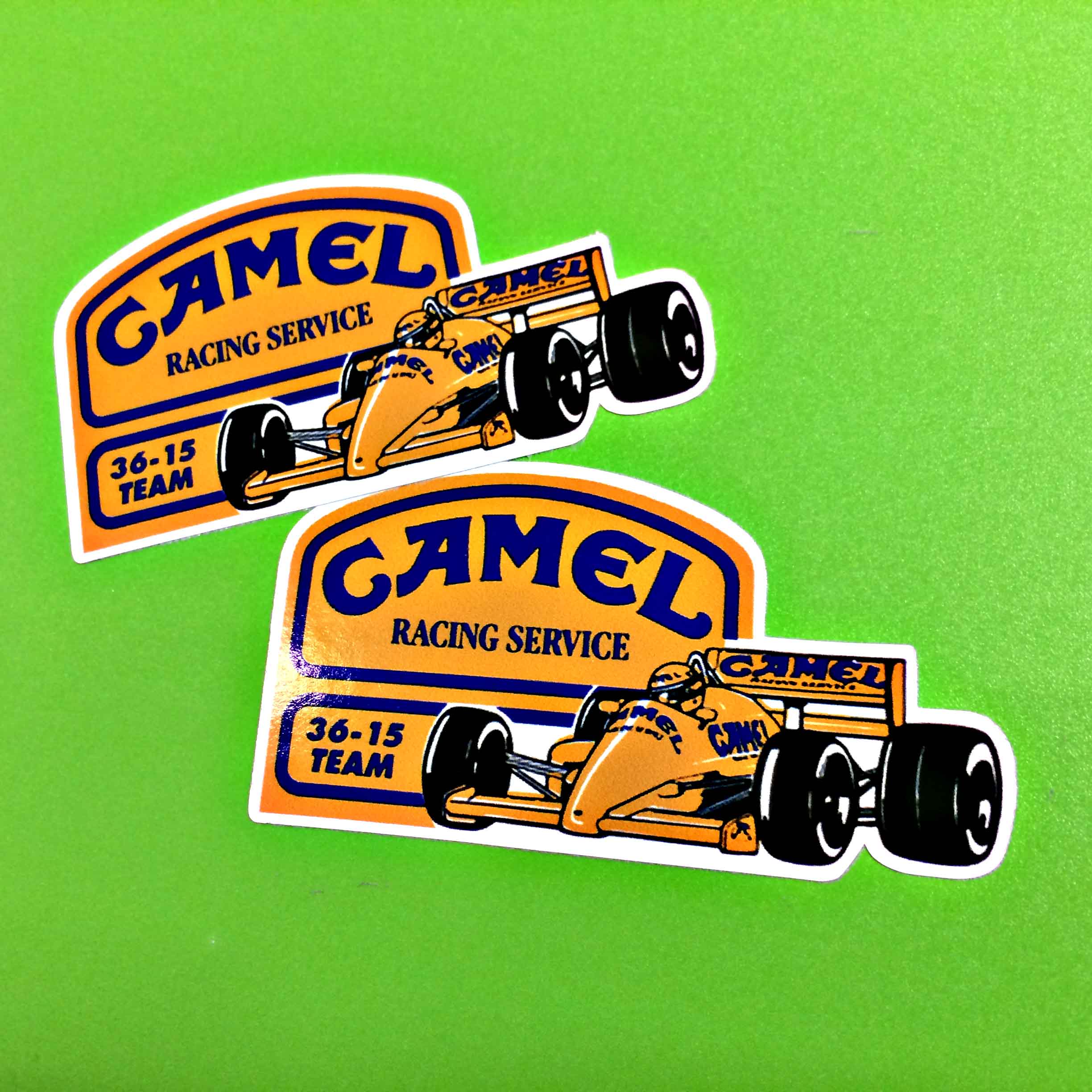 Camel Racing Service in blue lettering on a yellow background with a blue border; 36-15 Team in blue on a yellow background with a blue border next to a yellow F1 racing car with Camel logos on it in blue.
