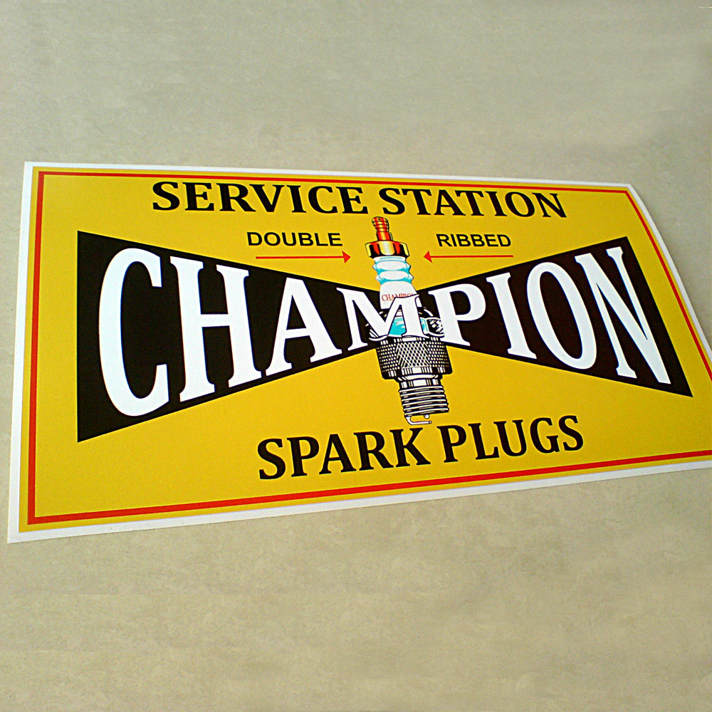 A yellow sticker with a red border. Champion in uppercase white lettering on a black background. In the centre is a spark plug. Additional text in black lettering; Service Station Double Ribbed (underlined in red) Spark Plugs.