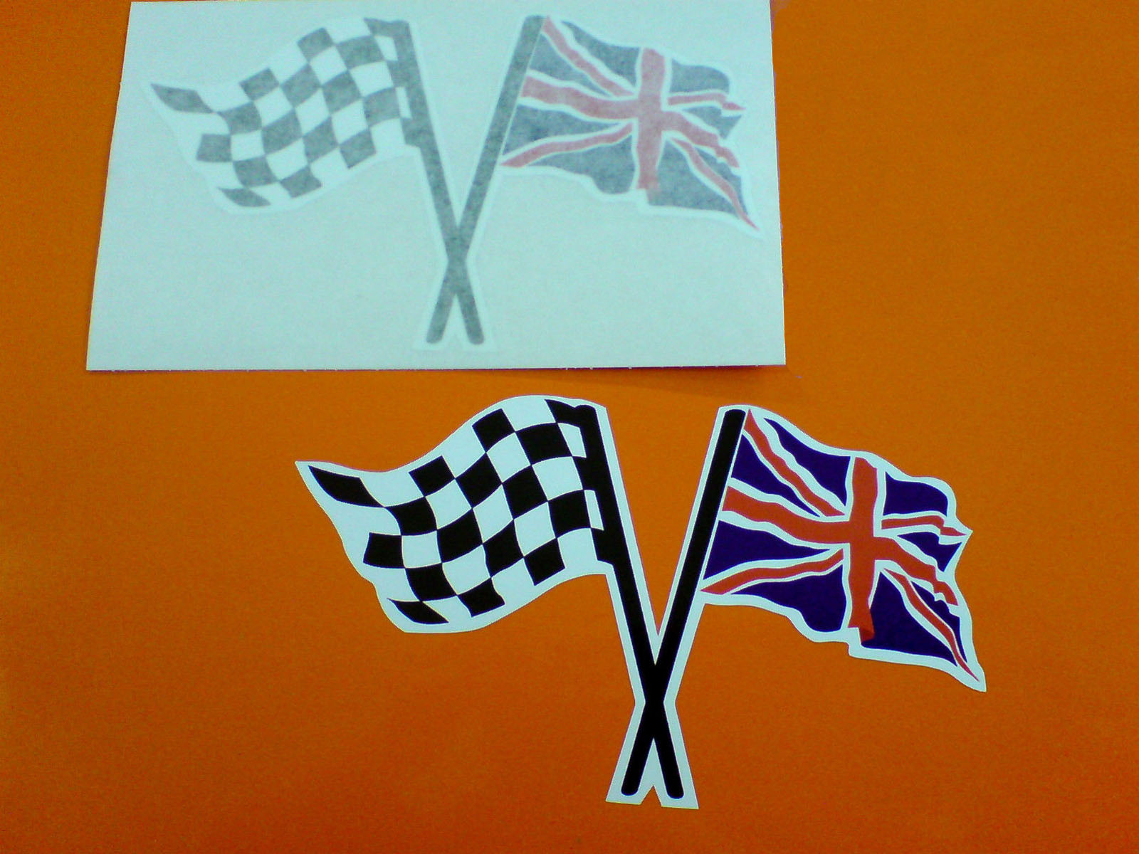Two crossed flags on poles. A black and white chequered and a red, white and blue Union Jack.