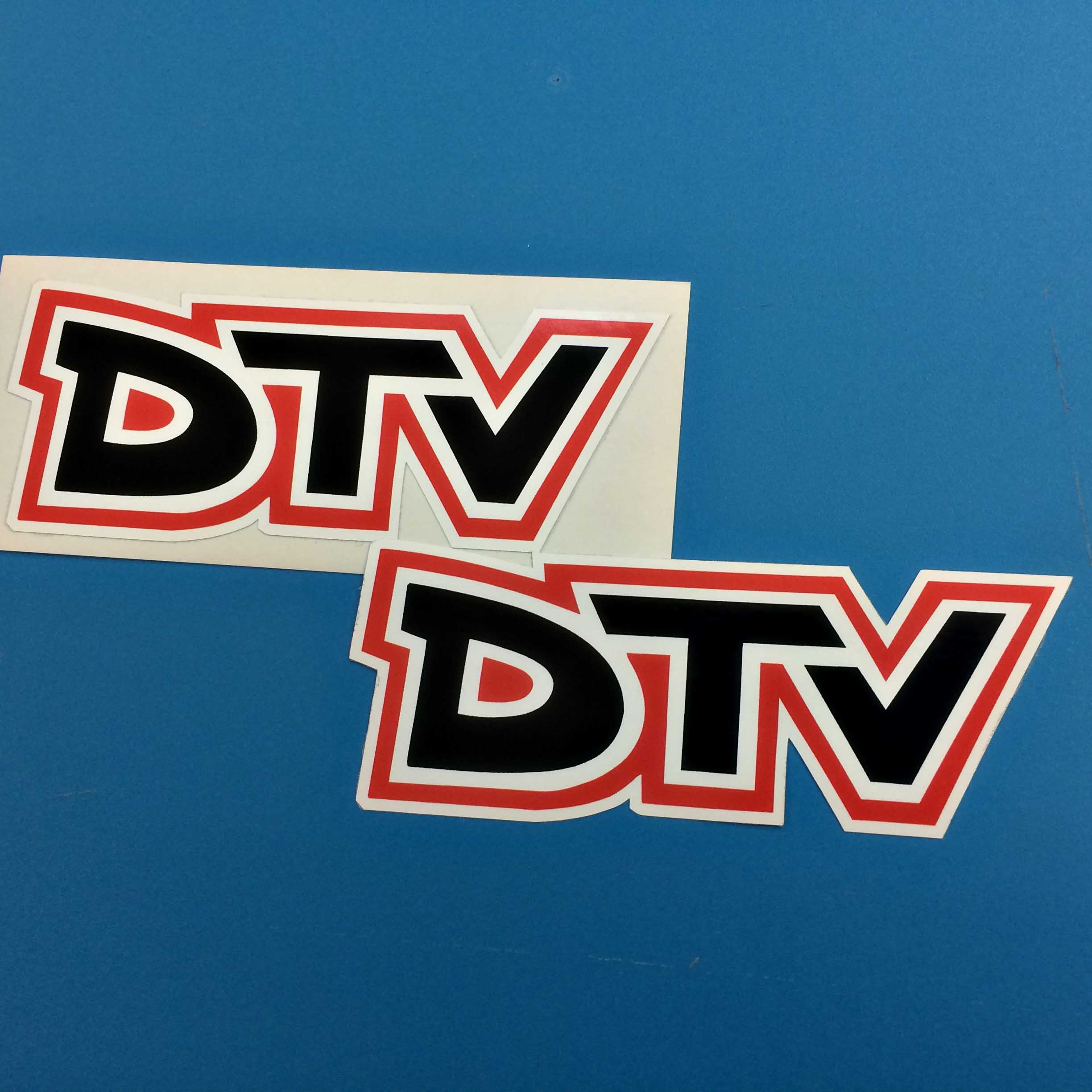 DTV CLASSIC STICKERS. DTV bold lettering in black. Letters are edged in white and red.