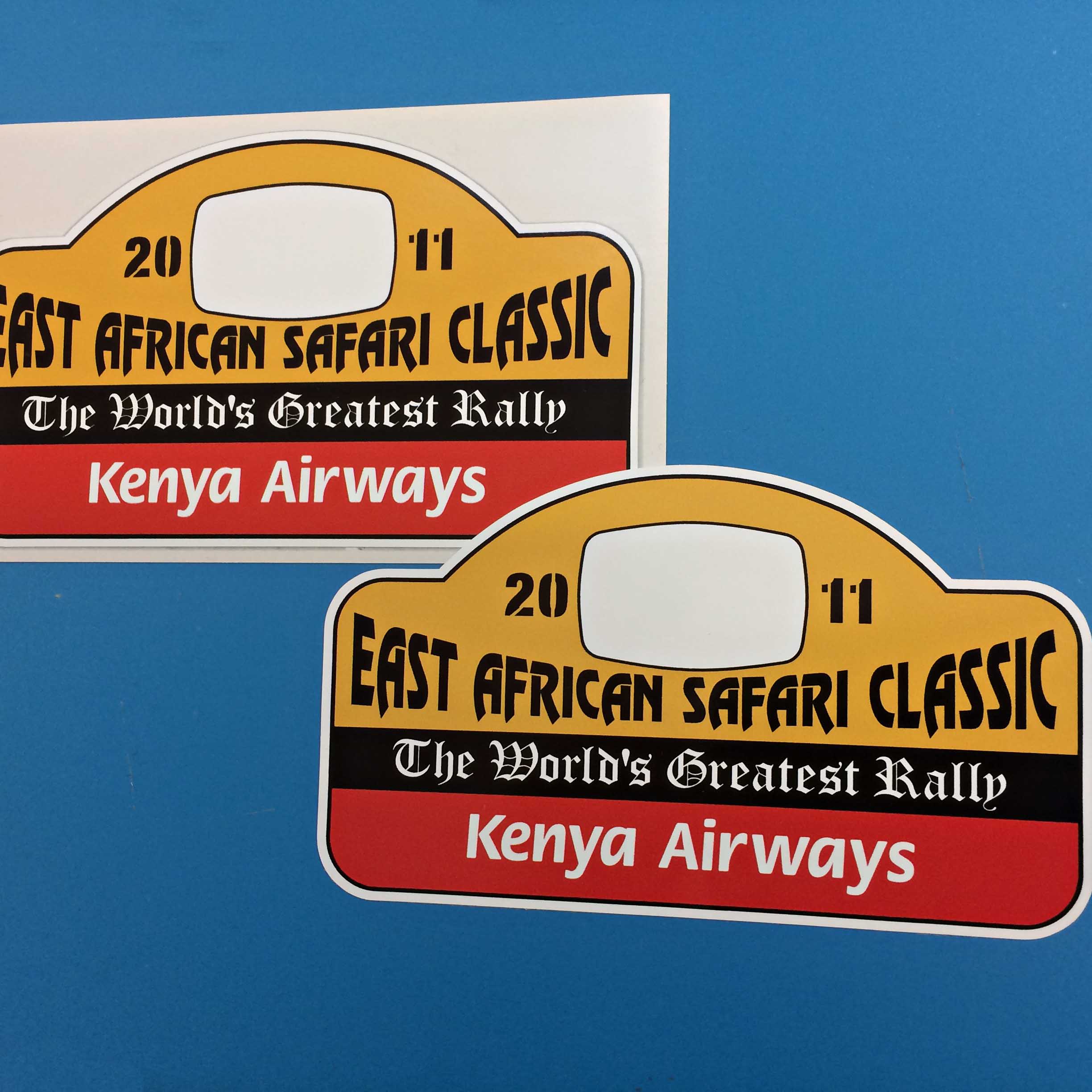 EAST AFRICAN SAFARI CLASSIC STICKERS. Three horizontal bands of colour. 2011 East African Safari Classic in black lettering on yellow. The World's Greatest Rally in white on black and Kenya Airways in white on a red band.