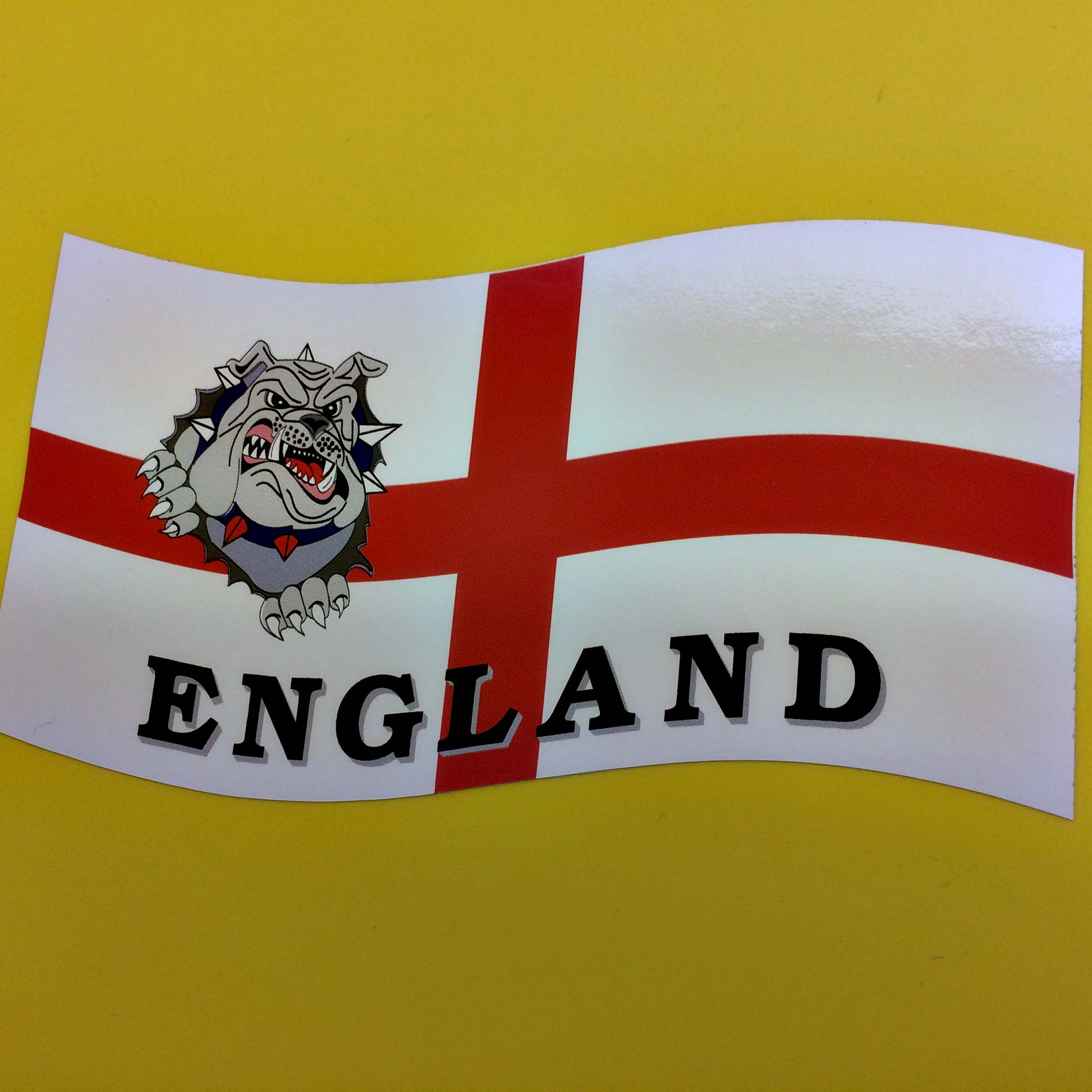 ENGLAND BULLDOG FLAG STICKER. An England flag; a red cross on a white field. Overlaying the flag is a bulldog and England in black lettering.