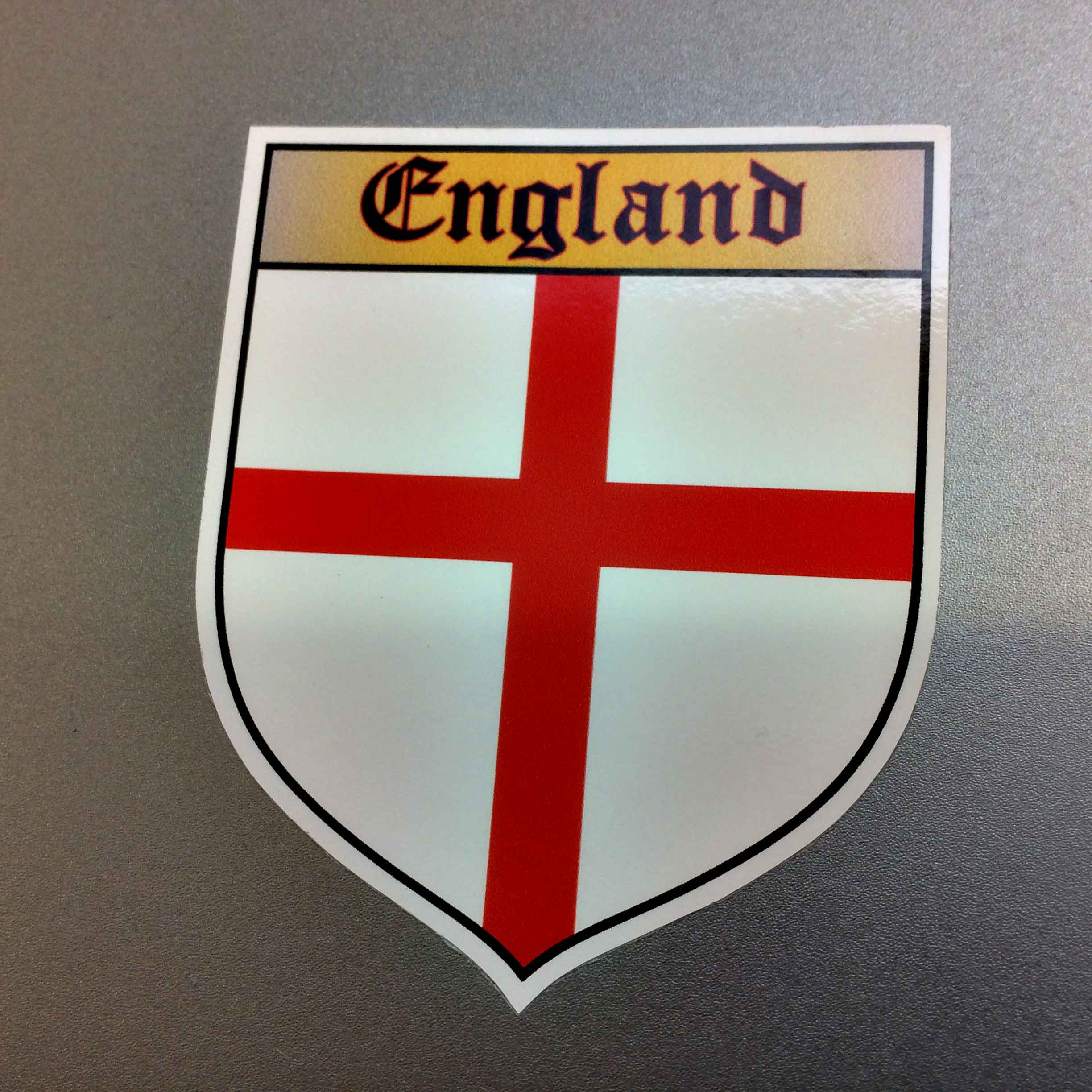 ENGLAND COUNTY SHIELD GB STICKER. An England shield. A red cross on a white field. Across the top on a gold banner is England in black Gothic font.