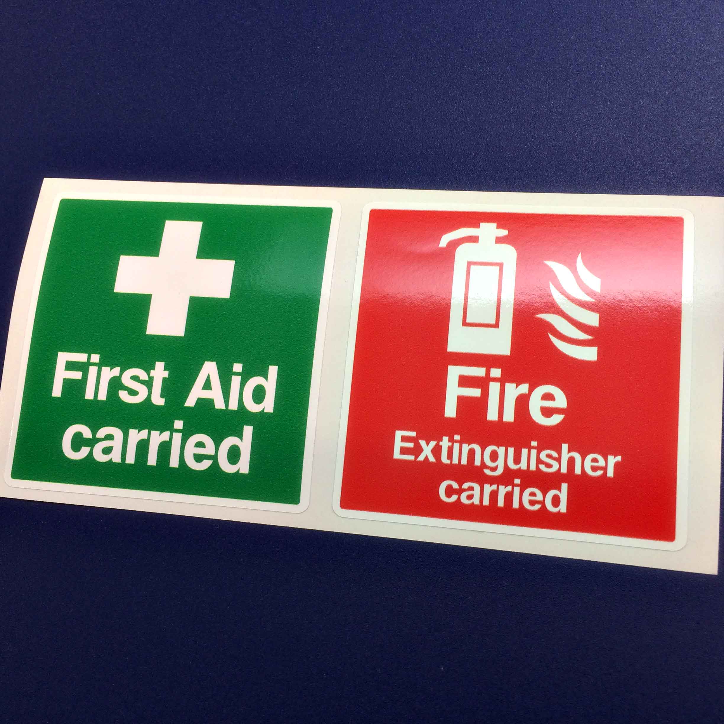 First Aid carried in white letters and a white cross on a green square. Fire Extinguisher carried in white letters and a white flame and fire extinguisher on a red square.