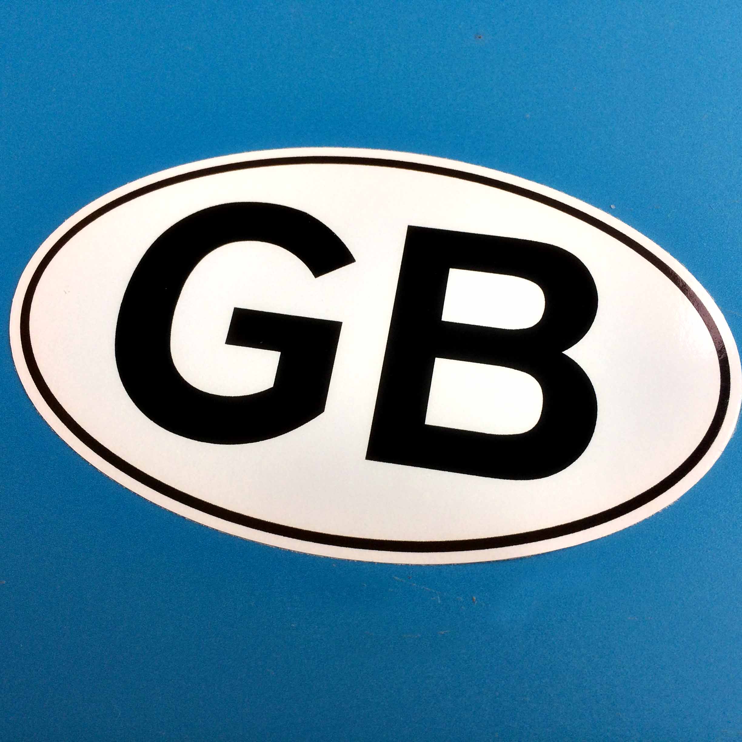 GB in bold black lettering on a white oval sticker bordered in black.