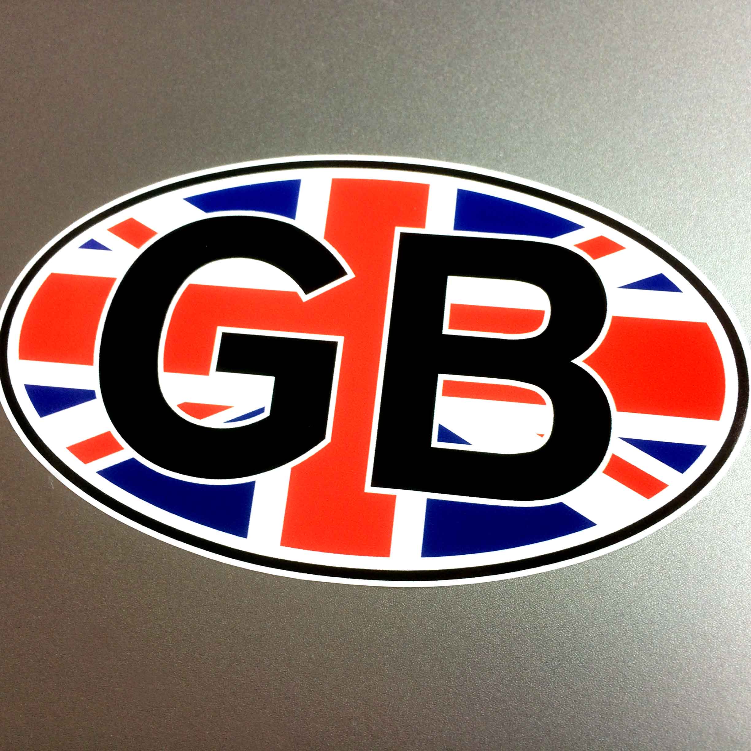 GB in bold black lettering overlays a Union Jack on an oval sticker bordered in black.