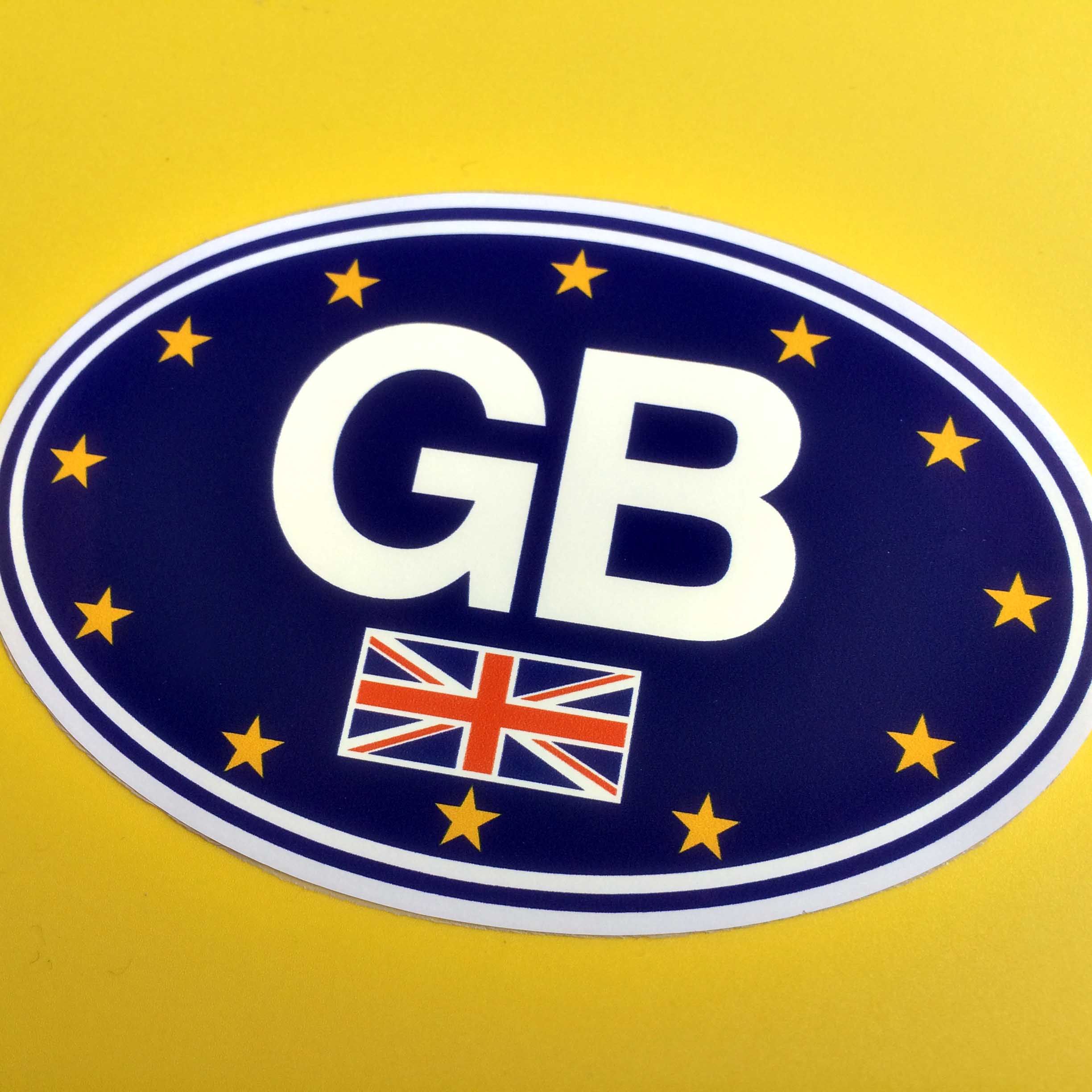 GB in bold white lettering and the Union Jack overlay the European flag on an oval sticker bordered in white.