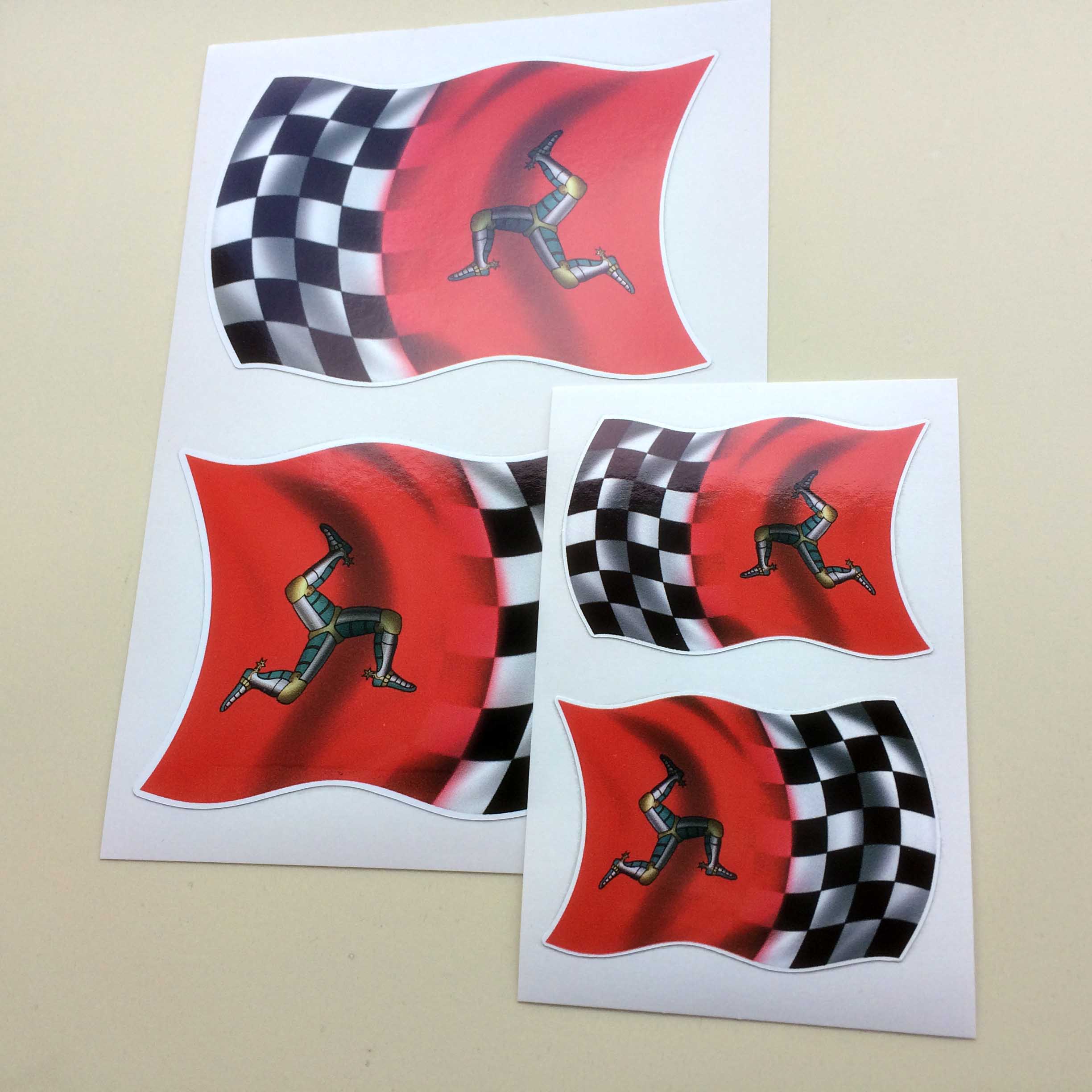 ISLE OF MAN FLAG STICKERS Three armoured legs with golden spurs on a red background and a black and white chequered flag. A wavy flag of two halves.