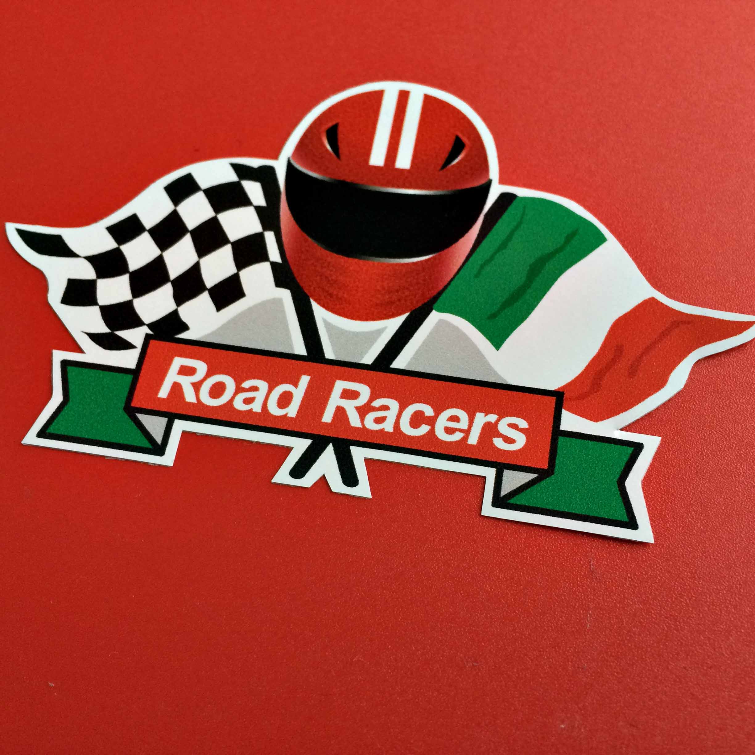 ITALIAN ROAD RACER STICKER. Road Racers in white lettering on a red and green banner. A red motorcycle helmet with two white vertical stripes sits between crossed flags; a chequered and Italy flag.