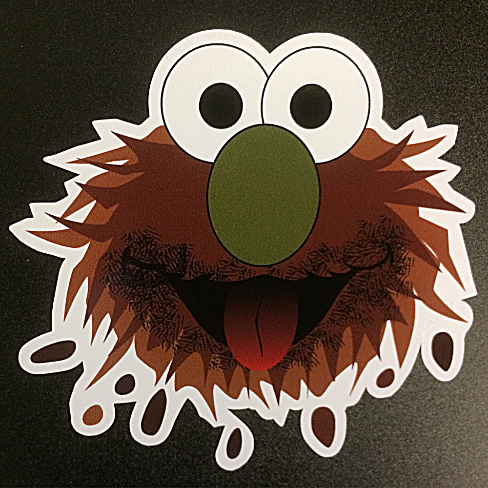 Muppet character with brown fur and droplets of mud. Eyes are white with black pupils. Nose is green and the tongue is red.