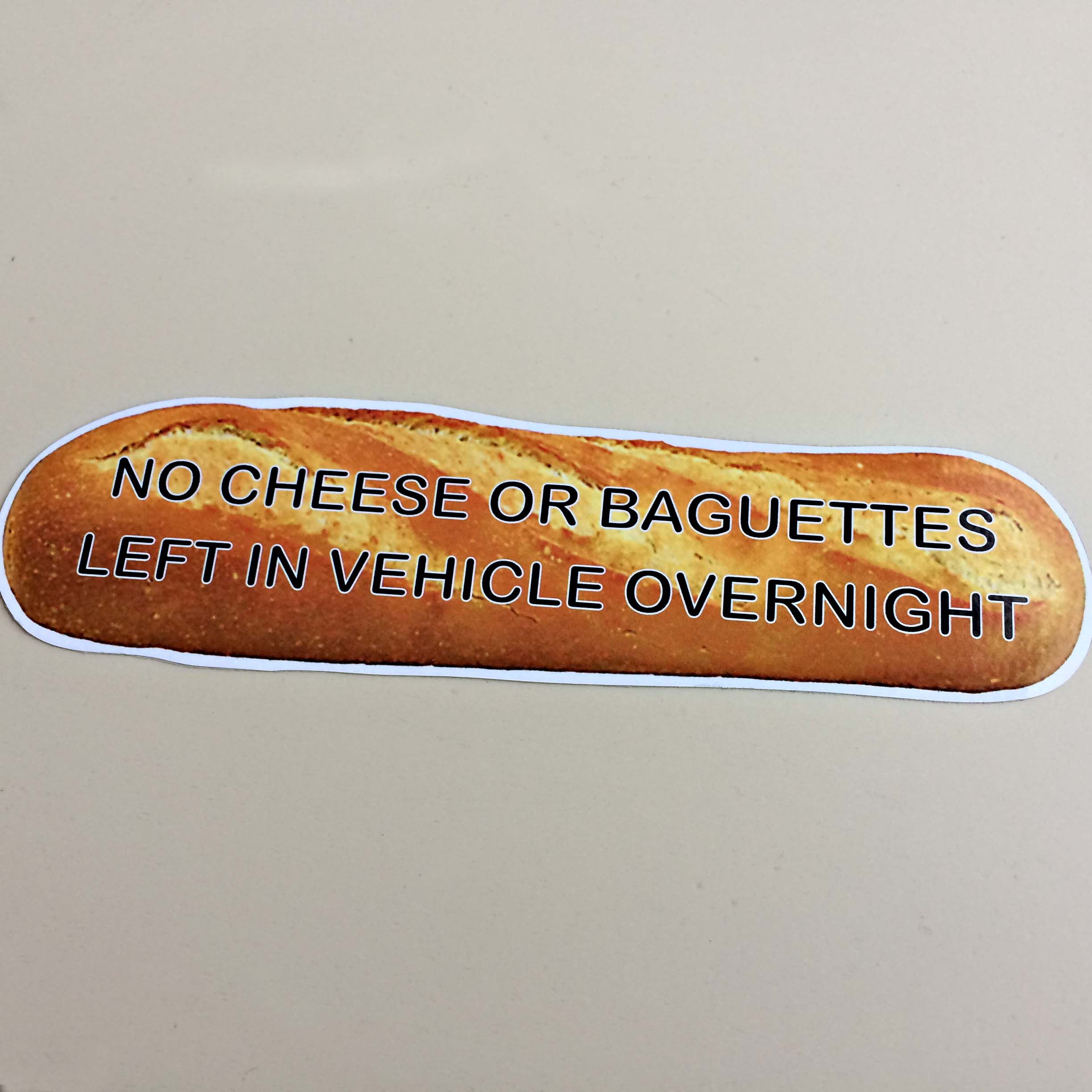 NO CHEESE OR BAGUETTES STICKER. No Cheese Or Baguettes Left In Vehicle Overnight. Black lettering on a baguette.