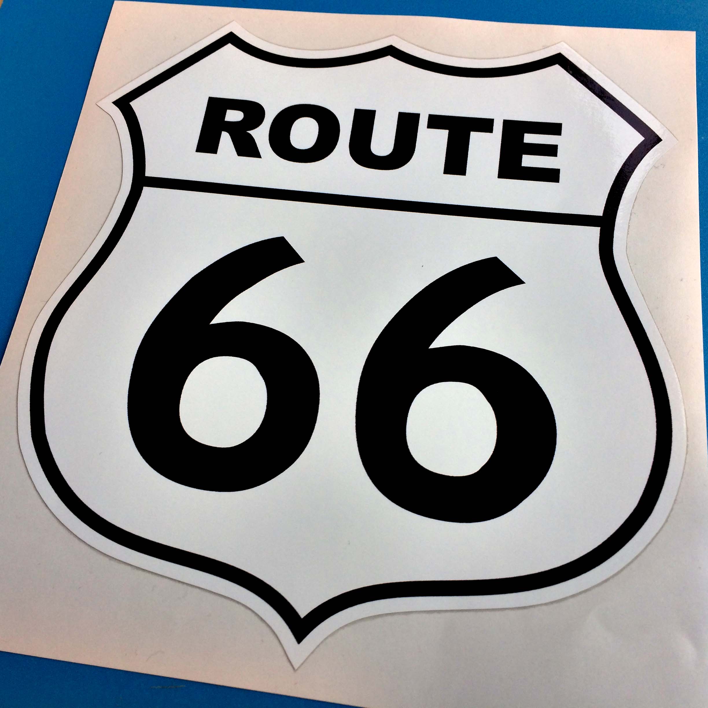 Route 66 in bold black lettering on a white Route 66 sign shaped sticker.