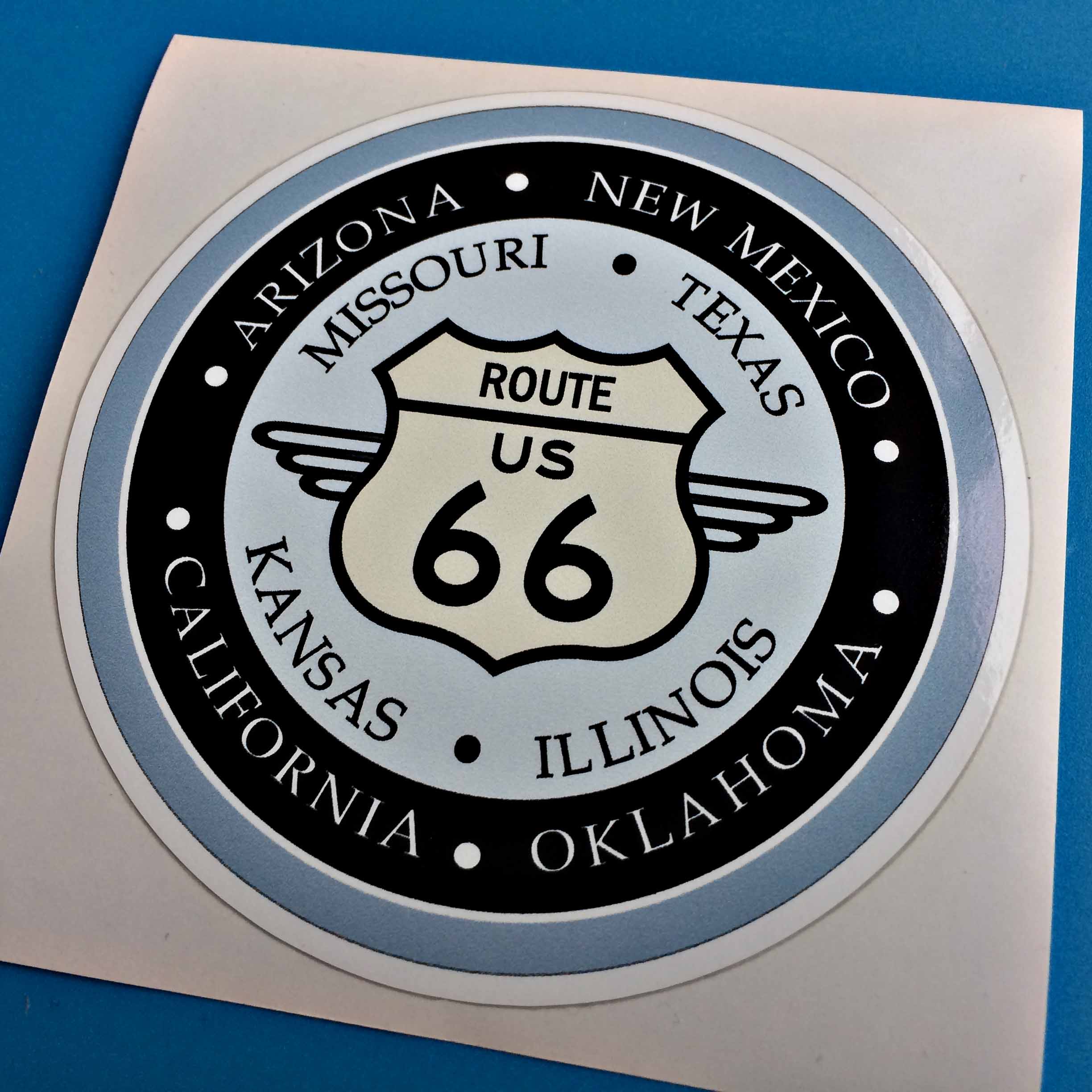 ROUTE 66 AND STATES STICKERS (BLUE RING). Route US 66 sign, Arizona, New Mexico, Missouri, Texas, Kansas, Illinois, California, Oklahoma. Black and white lettering within three concentric circles of black and blue.
