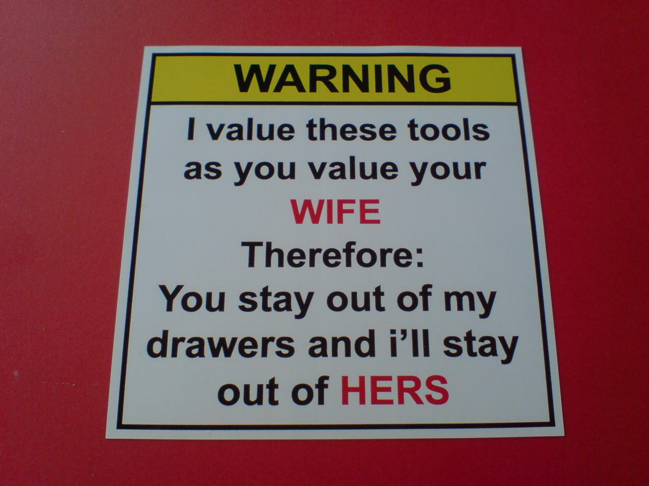 WARNING I VALUE THESE TOOLS STICKER. Warning in black lettering on a yellow banner. I value these tools as you value your wife. Therefore: You stay out of my drawers and I'll stay out of hers. Text is black. Wife and Hers is highlighted in red.