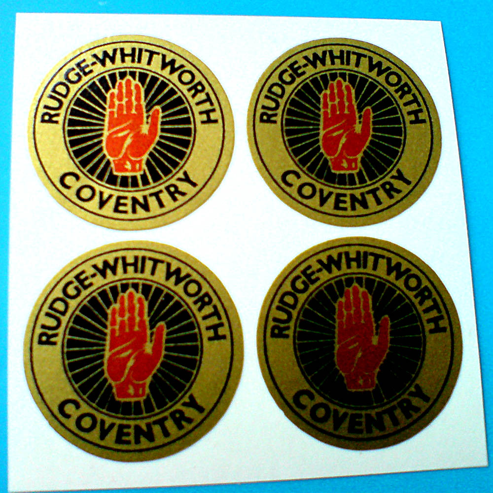 RUDGE WHITWORTH WIRE WHEEL STICKERS. Rudge-Whitworth Coventry in black lettering on a gold outer circle. Centre is a red hand on a gold spoked wheel.