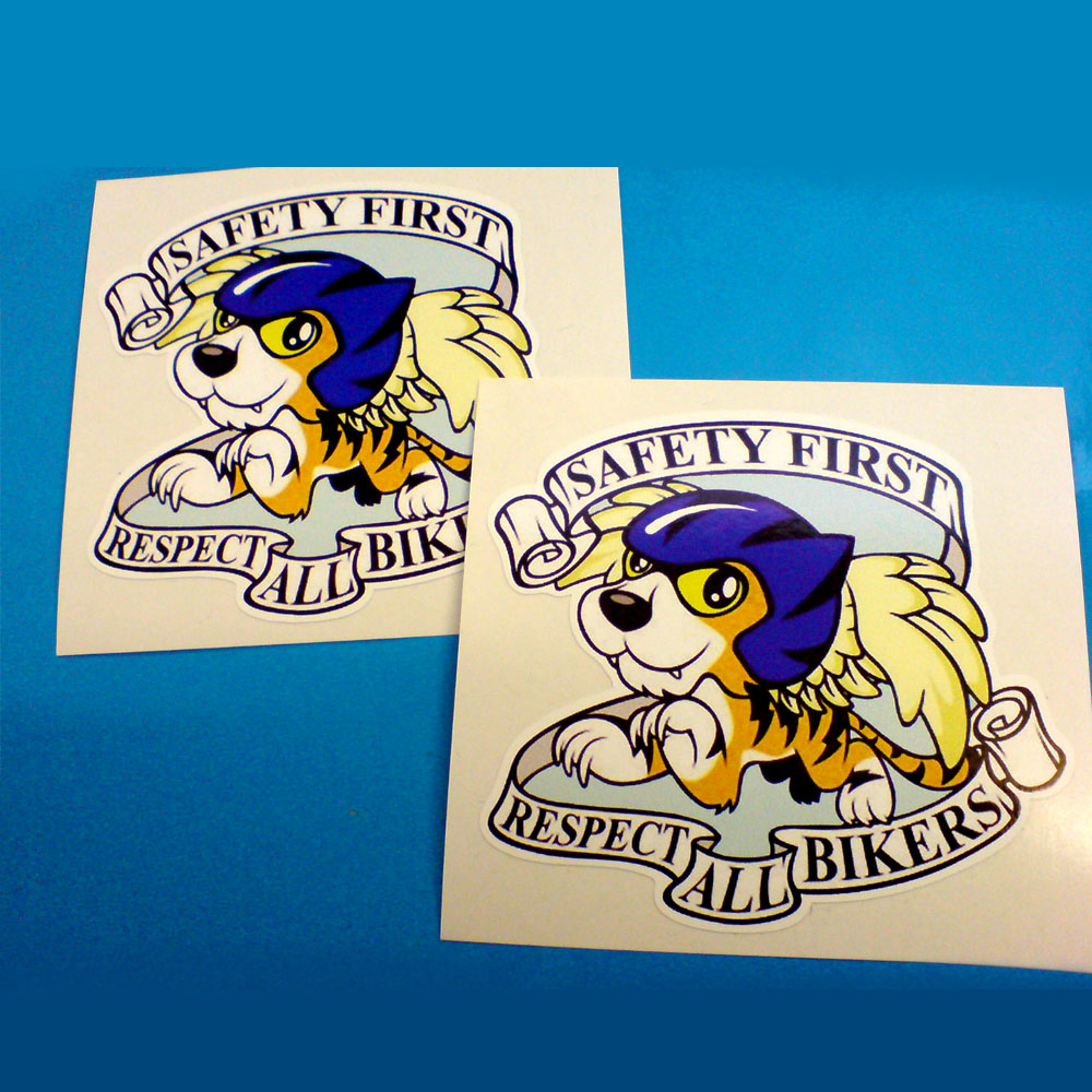 Safety First Respect All Bikers in black lettering on a white banner surrounds a pouncing tiger with yellow wings wearing a blue helmet.