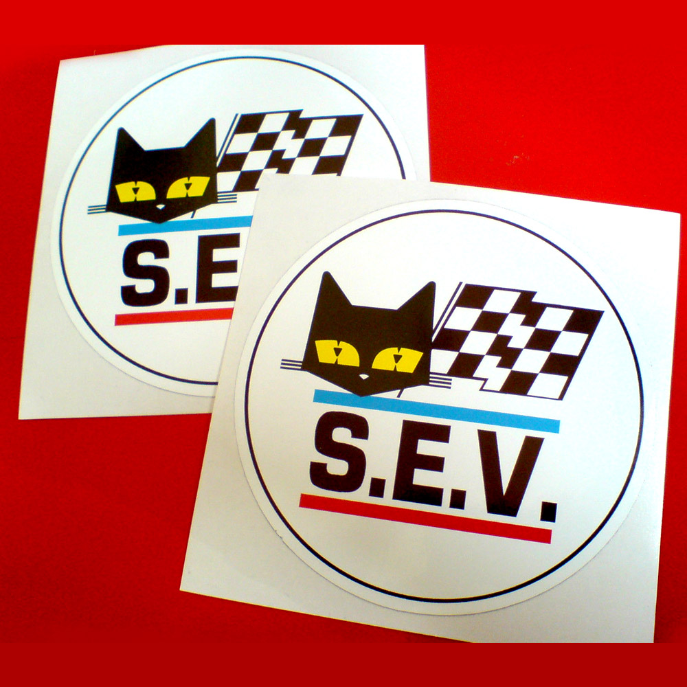 S.E.V. in bold black lettering between a blue and a red line. Above is the face of a black cat with yellow eyes next to a black and white chequered flag.