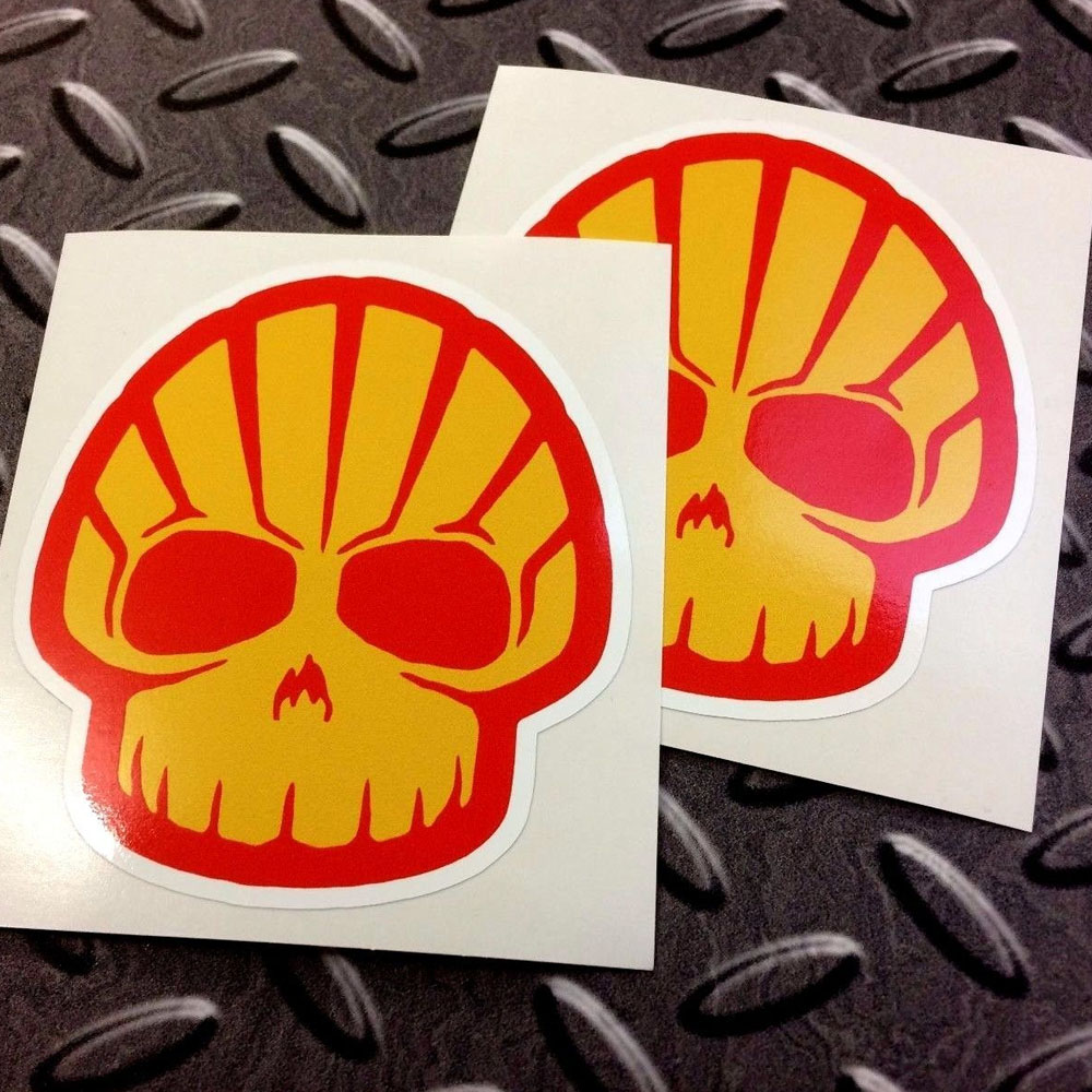 SHELL SKULL STICKERS. A yellow and red skull with red eyes on a white background. Looks like the Shell logo.