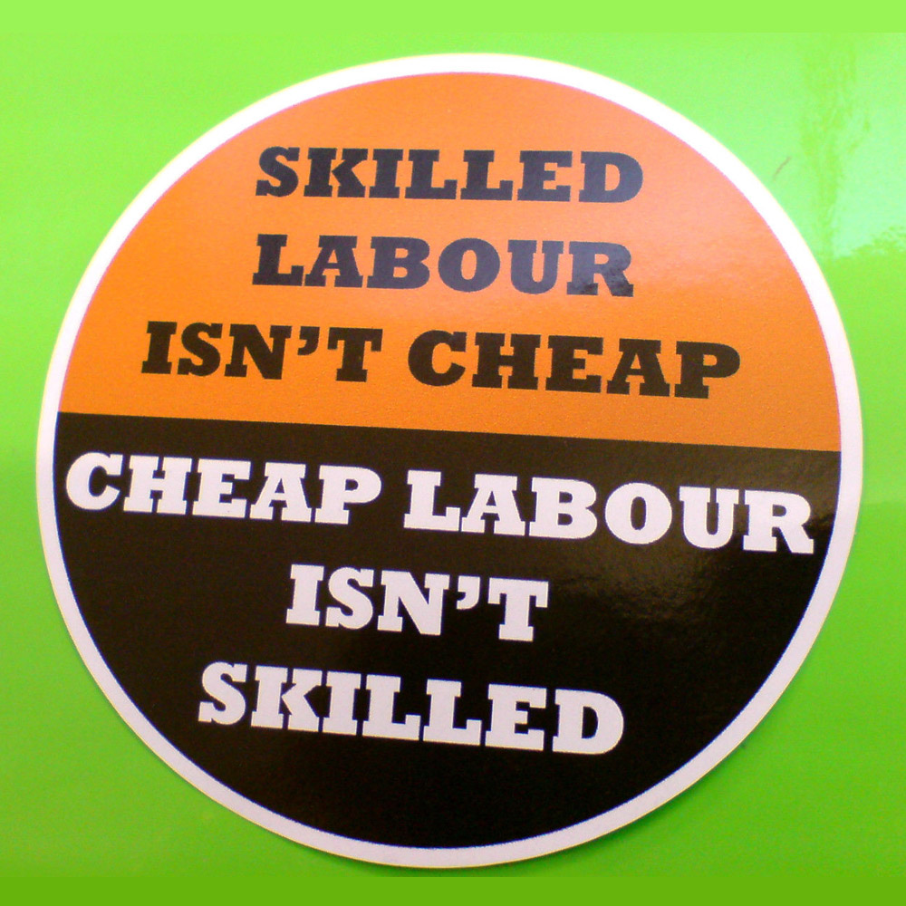 Skilled Labour Isn't Cheap in black letters on orange. Cheap Labour Isn't Skilled in white on a black background. A circular sticker in two halves.
