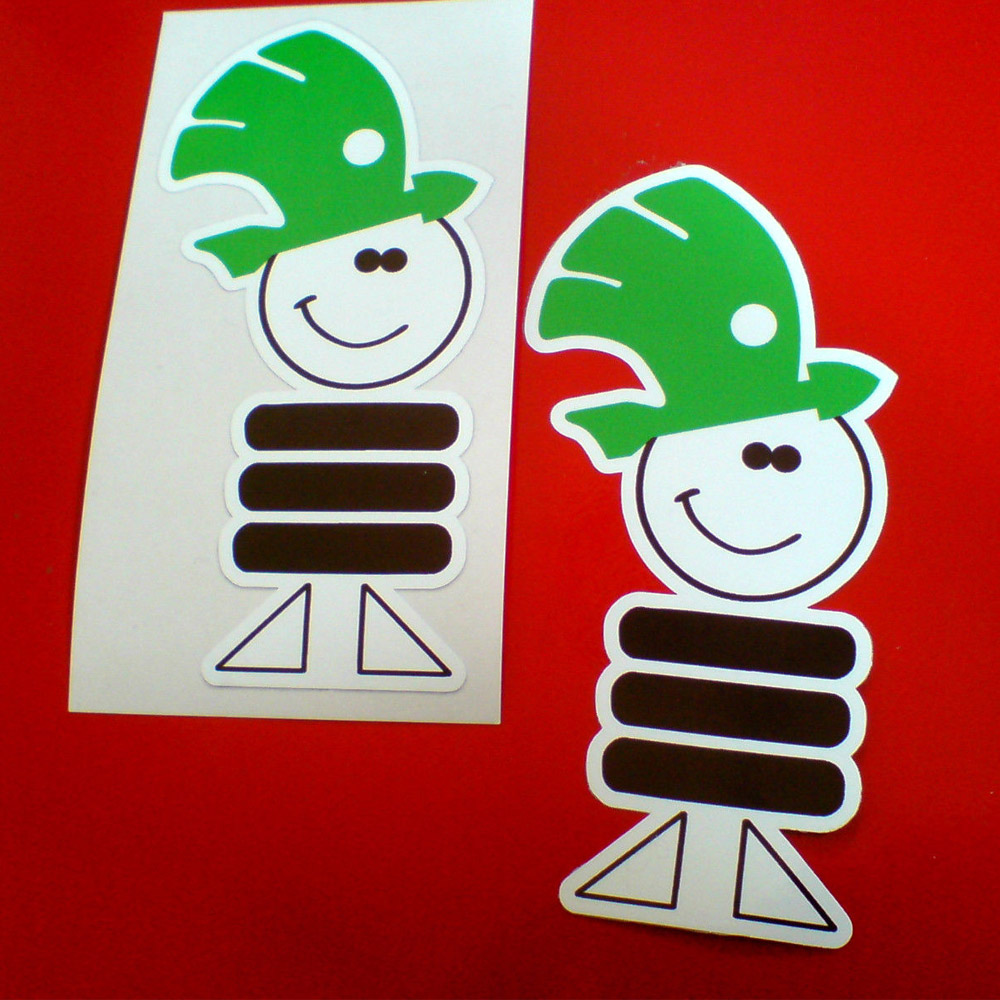 A smiley face character with feet and a body of three stacked car tyres. He is wearing the Skoda logo, a green winged arrow with feathers as a hat.