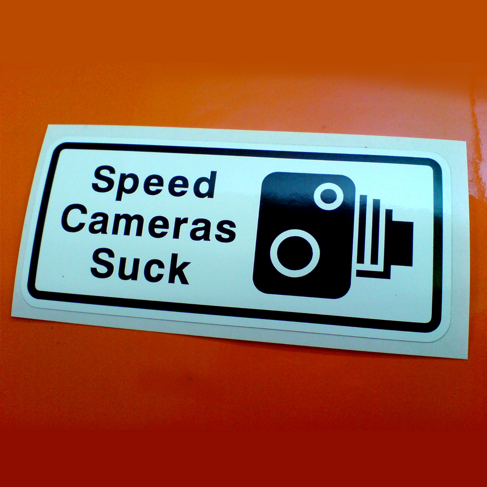 Speed Cameras Suck black lettering next to a black and white speed camera on a white background.