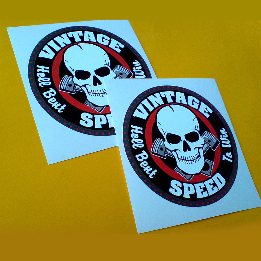 Three concentric circles in grey, black and red. Vintage Speed Hell Bent To Win in white lettering surrounds a skull and crossed pistons.