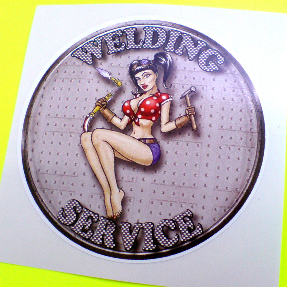 Welding Service in grey letters on a metal studded background surrounds a barefooted female in skimpy blue shorts and red spotted top baring her midriff. She is holding a welding torch and a hammer in gloved hands.