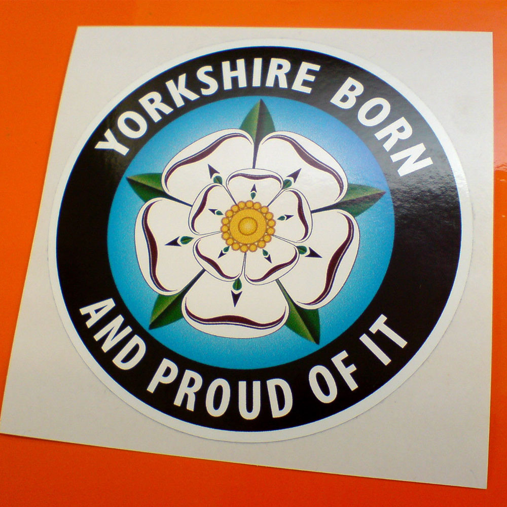 YORKSHIRE BORN STICKER. Yorkshire Born And Proud Of It in white lettering surrounds a black outer circle. The blue inner circle contains a white rose with five green sepals and a yellow centre.