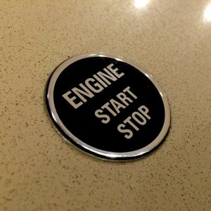 ENGINE START STOP DOMED RESIN GEL STICKER. Engine Start Stop in uppercase chrome lettering on a black background. Chrome edged round, domed sticker.
