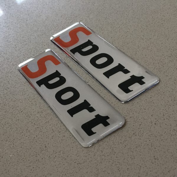 SPORT DOMED RESIN GEL STICKERS. Sport in lowercase lettering. The letter S is in colour red.