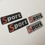 SPORT DOMED RESIN GEL STICKERS. Sport in lowercase lettering. The letter S is in colour red.