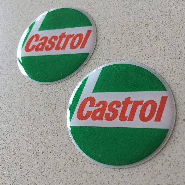 CASTROL STICKERS DOMED RESIN GEL - CLASSIC GREEN. Circular sticker in red, white and green. Castrol bold red lowercase lettering on a white L shaped background. White edge. Green background.