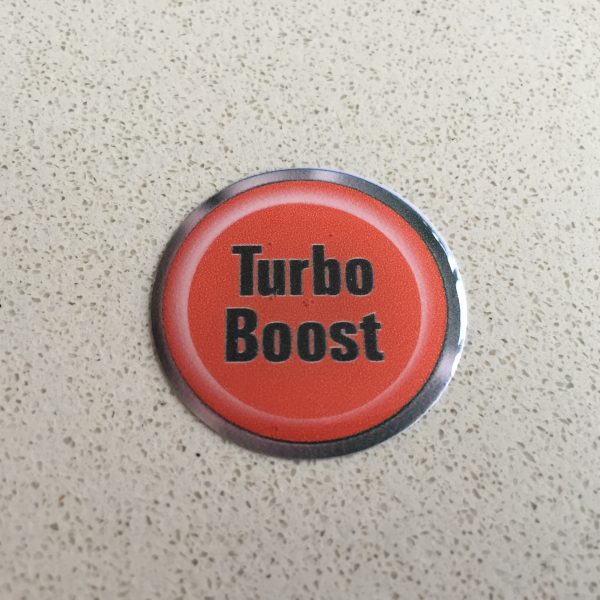 TURBO BOOST BUTTON DOMED RESIN GEL STICKER. Turbo Boost lowercase lettering in black on a red background.