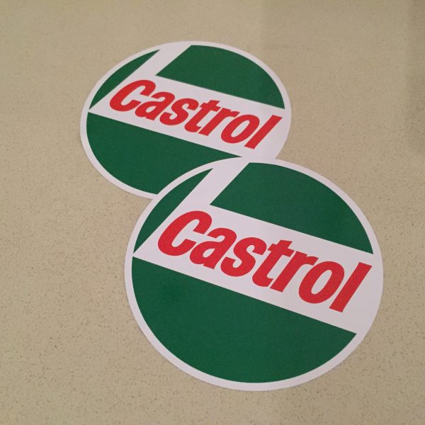 Circular sticker in red, white and green. Castrol bold, red, lowercase lettering on a white L shaped background. White edging. Green background.