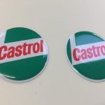 CASTROL STICKERS DOMED RESIN GEL - CLASSIC GREEN. Circular sticker in red, white and green. Castrol bold red lowercase lettering on a white L shaped background. White edge. Green background.