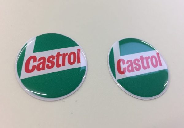 CASTROL STICKERS DOMED RESIN GEL - CLASSIC GREEN. Circular sticker in red, white and green. Castrol bold red lowercase lettering on a white L shaped background. White edge. Green background.