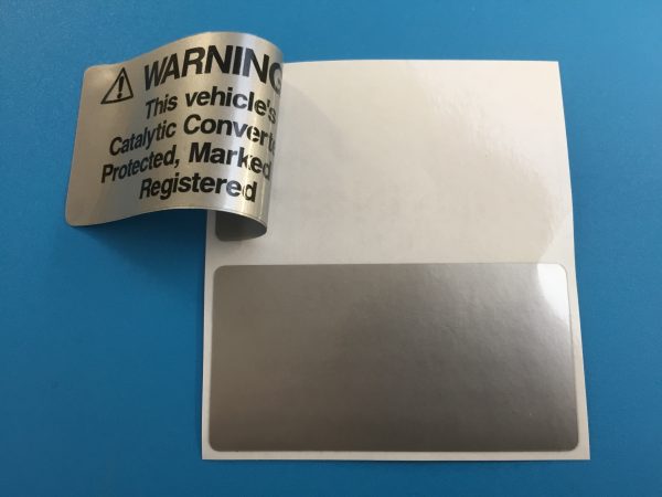 Catalytic Convertor Warning Stickers. Black text on either a yellow, white or silver background. With the word Warning in bold capital letters. The rest of the text 'This vehicle's Catalytic Converter is Protected, Marked and Registered' in lower case.