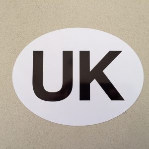 White oval shaped sticker, with letters UK printed in black.