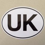 UK in bold black lettering on a white oval sticker with a black border.