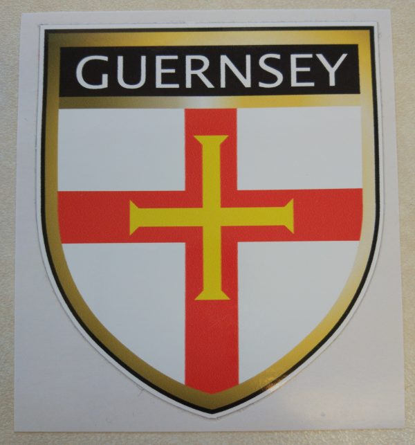 Guernsey in white lettering on a black banner at the top of the shield. Below is a red cross with a gold cross within it on a white field.