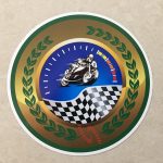 MOTORCYCLE SPEEDWAY RACING STICKERS. A man racing a motorcycle on a speedway and a chequered flag overlays a speedometer. A green laurel leaf on a gold background surrounds the image.