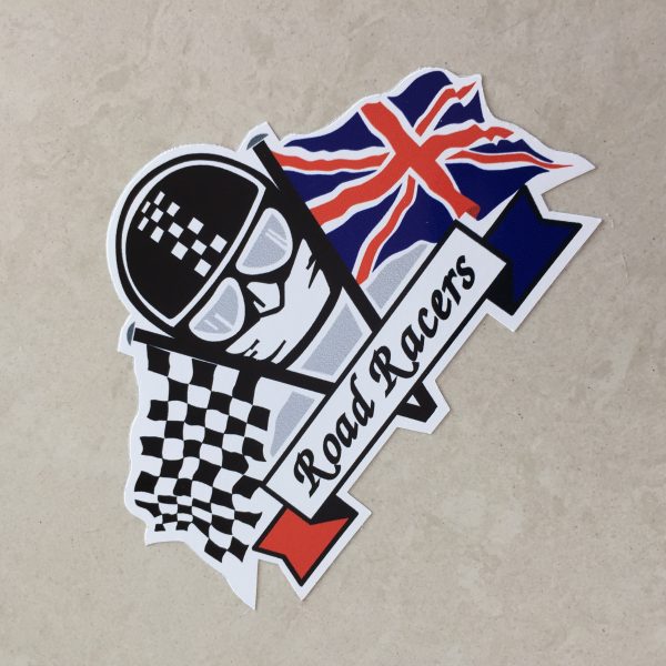 CHEQUERED UNION JACK ROAD RACERS STICKER. Road Racers in black lettering on a white banner. Behind are crossed chequered and Union Jack flags. The face of a motorcyclist wearing helmet, goggles and scarf sits between.