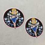 LADY LUCK STICKERS. Lady Luck in silver lettering on a black background. A blonde pin up wearing a number 8 bikini top and four aces sarong with a horseshoe in her hair. She stands in front of crossed chequered flags while holding a tool and a clover leaf.