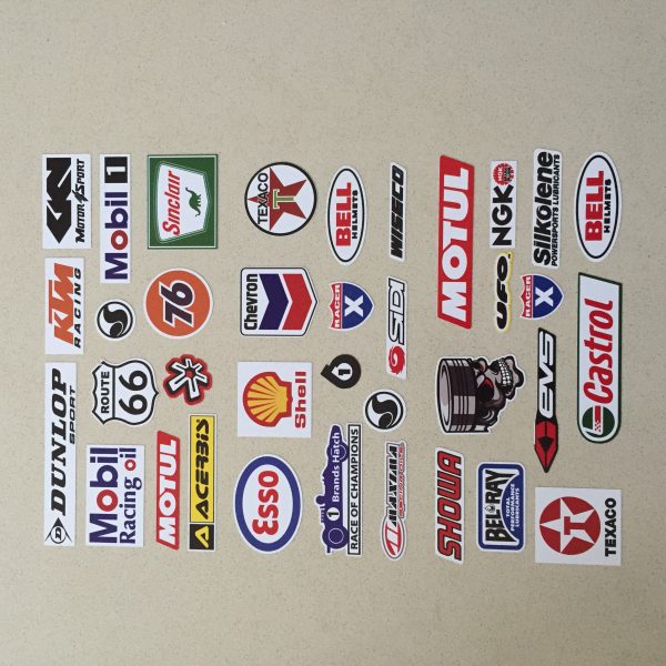 An assortment of stickers. Logos including Texaco, Castrol, Bell Helmets, Esso, Shell, Dunlop, Route 66 and more.