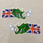 UNION JACK WARTHOG STICKERS. A green headed warthog with red eyes and white horns. Air is expelling from the nostrils. A Union Jack flag is flowing behind.