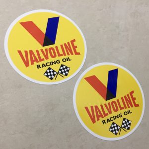 VALVOLINE RACING OIL STICKERS. Valvoline in red and Racing Oil in black uppercase lettering. Above is the letter V in red and blue. Below are two crossed chequered flags on a yellow circular sticker.