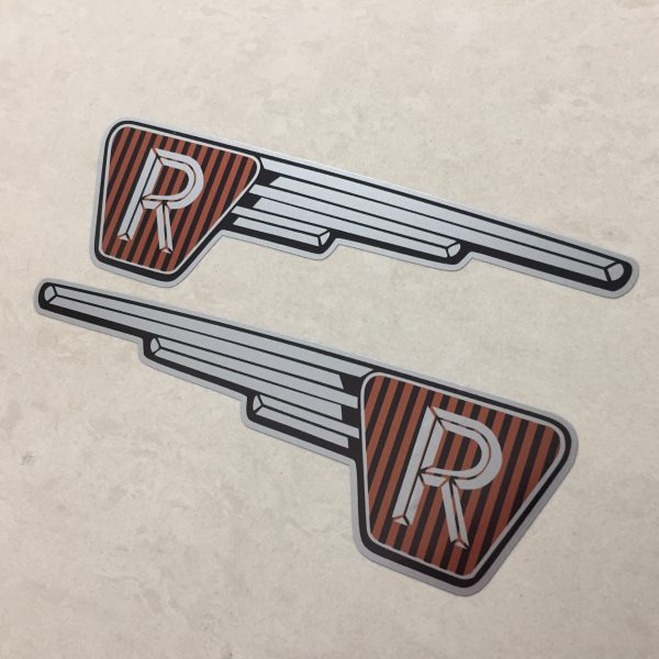 RALEIGH RUNABOUT FAIRING STICKERS. The letter R in silver on a black and brown vertical striped background inside an inverted triangle. A silver wing effect protrudes from one side.