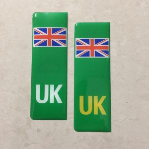 Two green columns. UK in white at the base of one column. UK in yellow on the other. Both stickers have the Union Jack at the top.